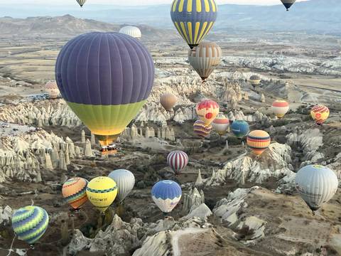 Hot air balloons flying over the unique rock formations in Cappadocia.