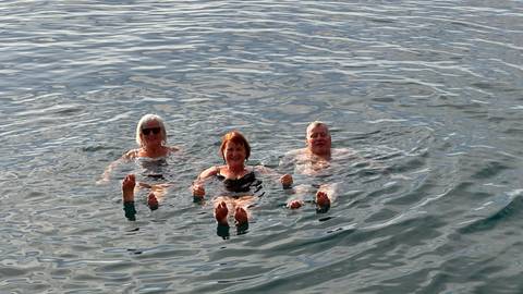 Three people enjoying a swim in the sea.