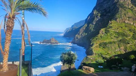 Cliffside view with ocean waves crashing against the rocks.