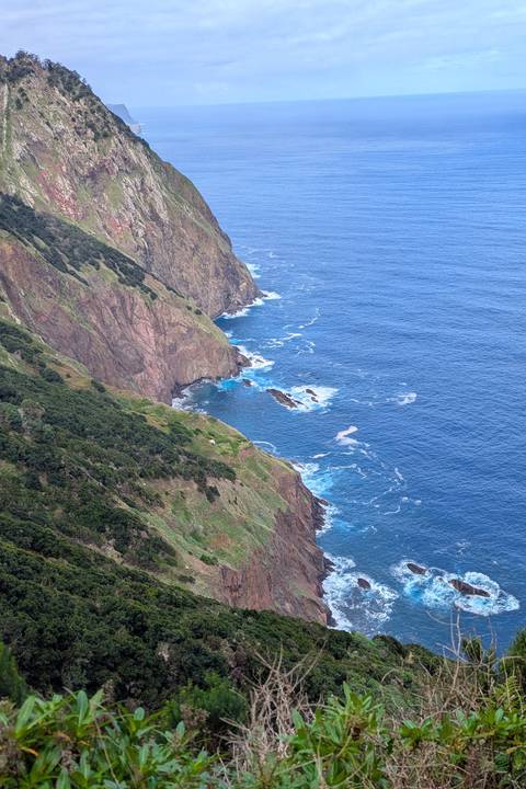 Coastal cliffs and blue ocean with waves.