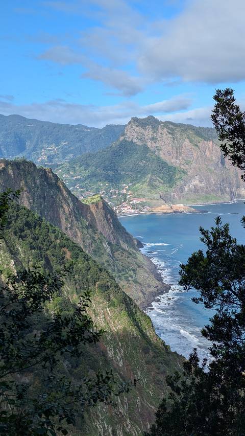 A coastal view with cliffs and a small town in the background.