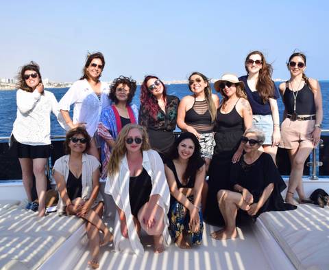 A group of people on a boat with a sea backdrop.