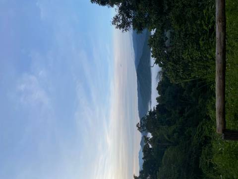 Panoramic view of mountains and forest with clouds at sunrise.