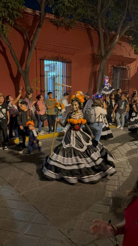 Character in costume with flowers during a parade.