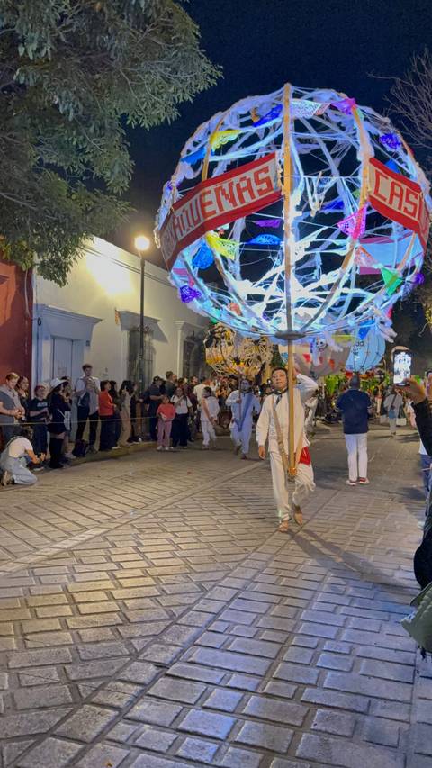 Parade with person carrying a large decorated pole.