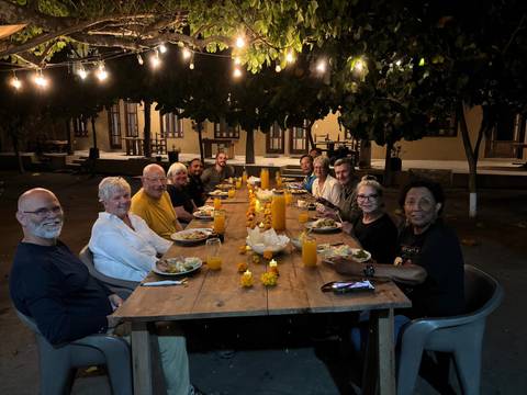 Group dining outdoors under string lights.