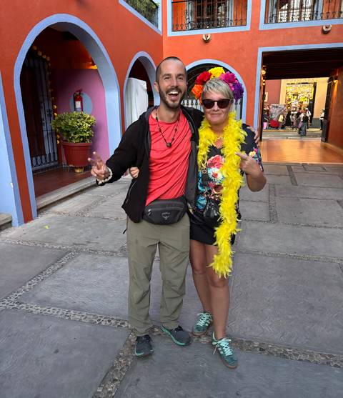 Two people posing in colorful clothing.