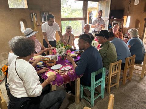Group of people dining indoors with a festive setting.