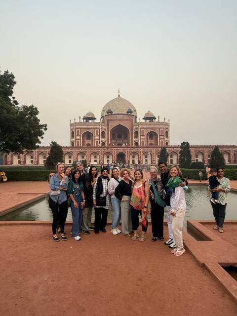 Tourists posing in front of Humayun's Tomb with a reflection pool.