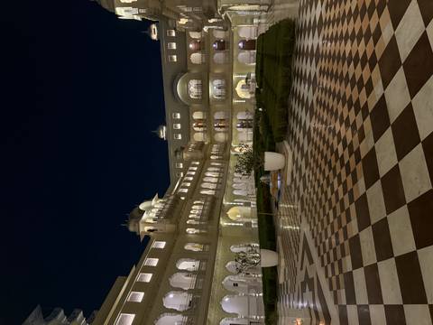 Night view of a grand architectural building with lit arches.