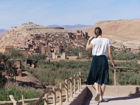 Person overlooking the historic site of a town with rugged terrain.