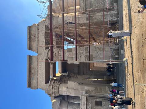 Ancient temple facade under restoration with scaffolding.