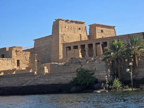 Ancient temple ruins with palm trees.