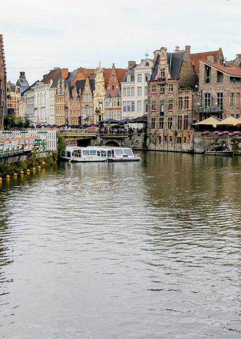 Canal with boats and historic buildings, lively ambiance.