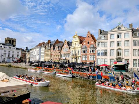 Crowded canal scene with boats and historic architecture.