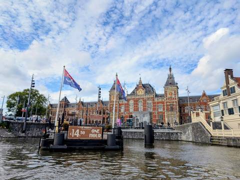 Historic museum building with flags, viewed from the water.