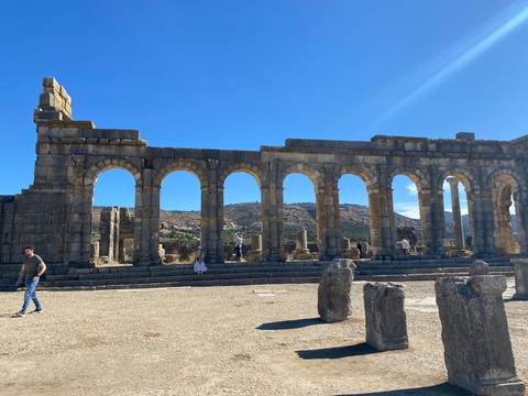 Ruins of a Roman aqueduct with rural scenery.