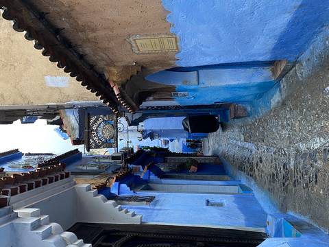 Narrow alleyway with blue-washed walls in a town.