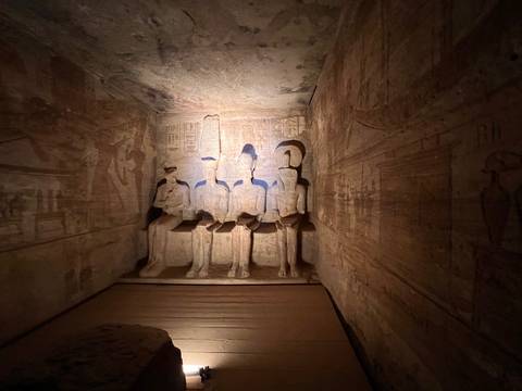 A group of four statues in an Egyptian temple setting.