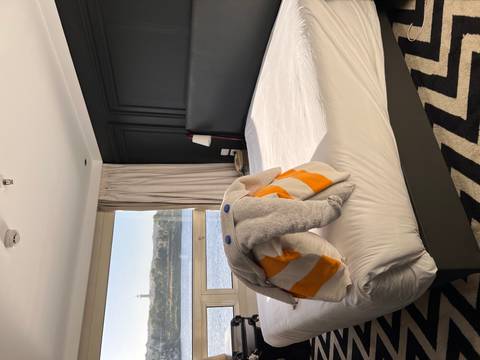 Hotel room with a creatively folded towel on the bed, overlooking a river.