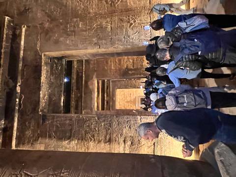 A crowded entrance to an ancient Egyptian temple with many tourists.