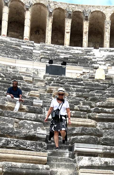 People sitting on ancient theater steps.