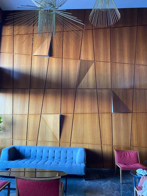 Wooden wall with geometric patterns and shadows.
