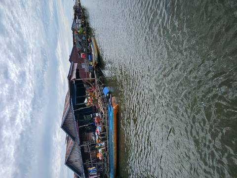 Floating houses and boats on a river.