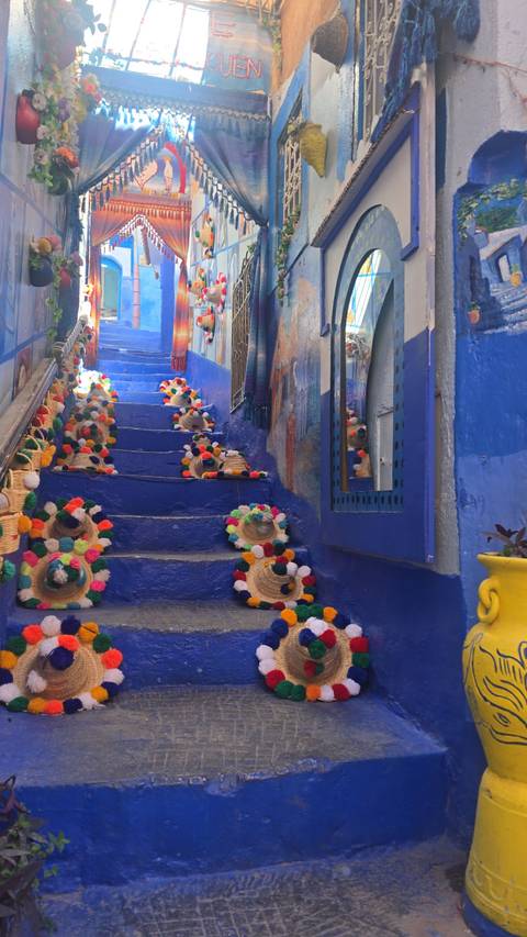 Decorated blue stairway with hats in Chefchaouen.