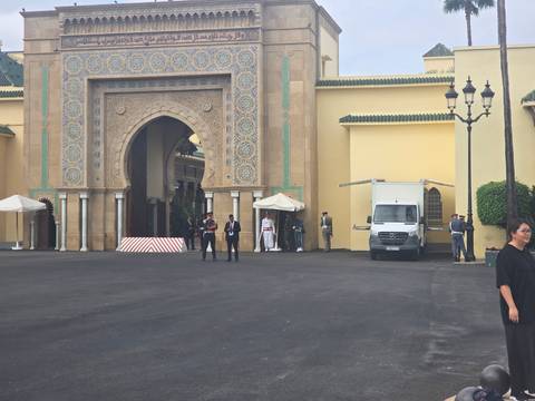 A large and ornate building with elaborate patterns and people standing around.
