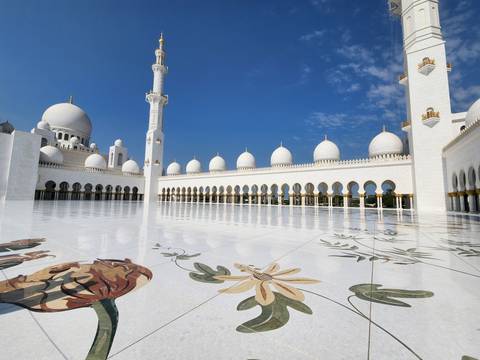 A grand white mosque with domes and minarets.
