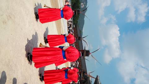 Traditional Korean guards in red attire during a ceremony.
