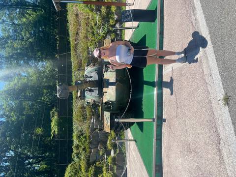 Woman posing with a tank in a military park.