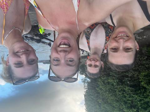 Women by the seaside smiling and posing.