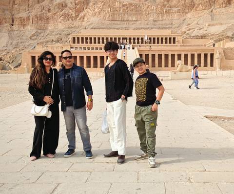 A family posing in front of an ancient Egyptian temple.
