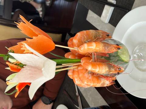A decorative shrimp dish with carved vegetables.