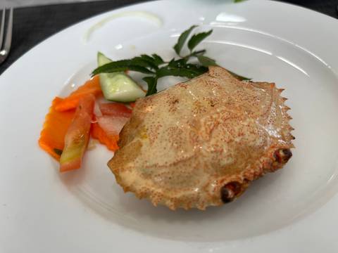 A crab dish served with vegetables on a plate.