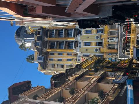 Tall ornate building against a blue sky in a cityscape.