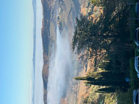 Scenic view of hills with fog and distant trees.