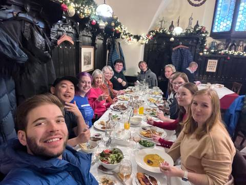 Group of people dining at a festive table indoors.