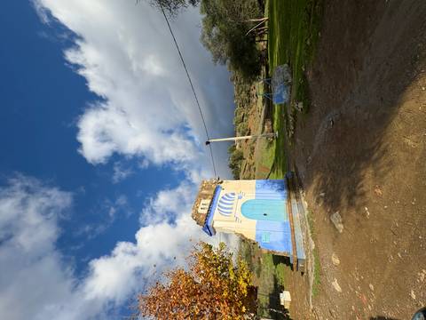 Small building with blue and white artwork in rural area
