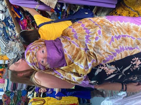 Market scene with people wearing colorful traditional clothing.