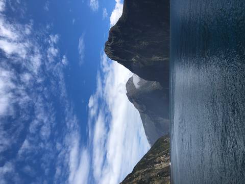 Mountain range with sea inlet under a clear blue sky.