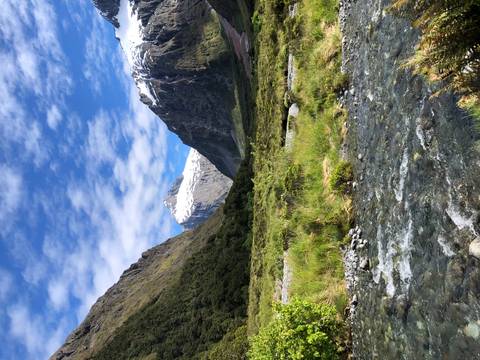 River flowing through a lush valley with mountains.