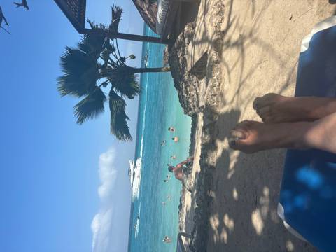 Feet with a beach and ocean in the background.