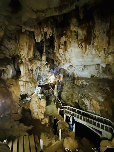 Large cave interior with stalactites and path lighting.