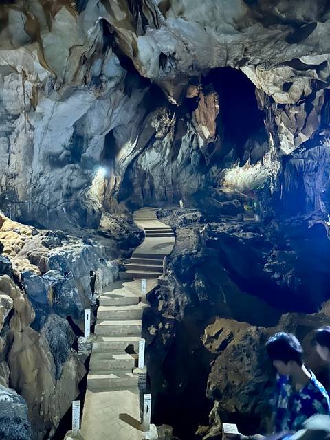Pathway through a cave with stalactites and ambient lighting.