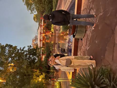 People standing near a lit area with decorative water features.