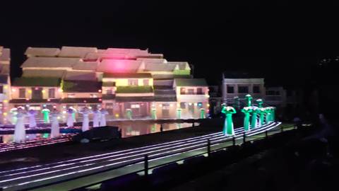 Blurry evening performance scene with lights and dancers.