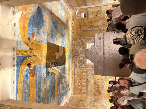 Interior of a tomb with wall paintings and visitors